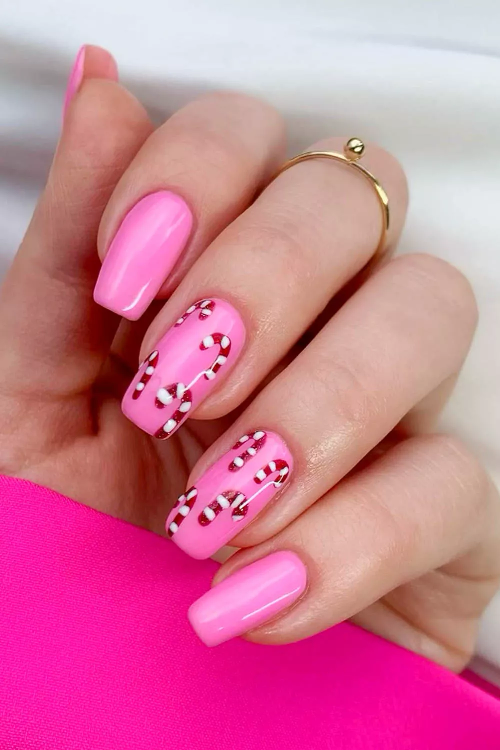uñas rosas con decoracion de bastones de caramelo navideños