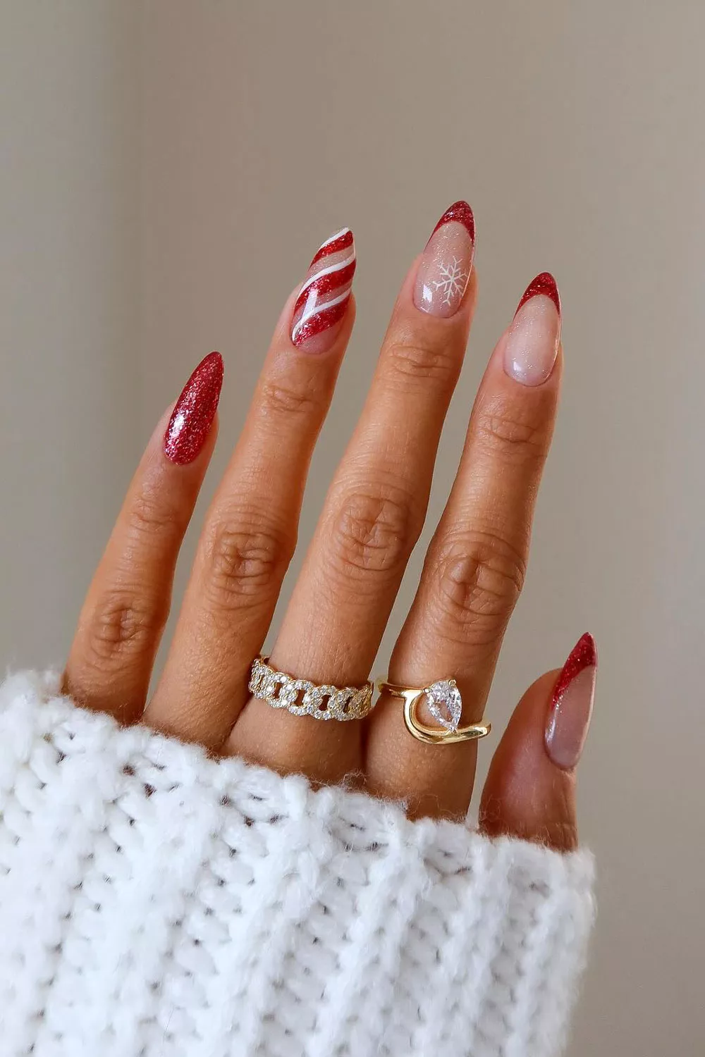 uñas de navidad rojas elegantes con lineas en blanco de baston de caramelo y copo de nieve
