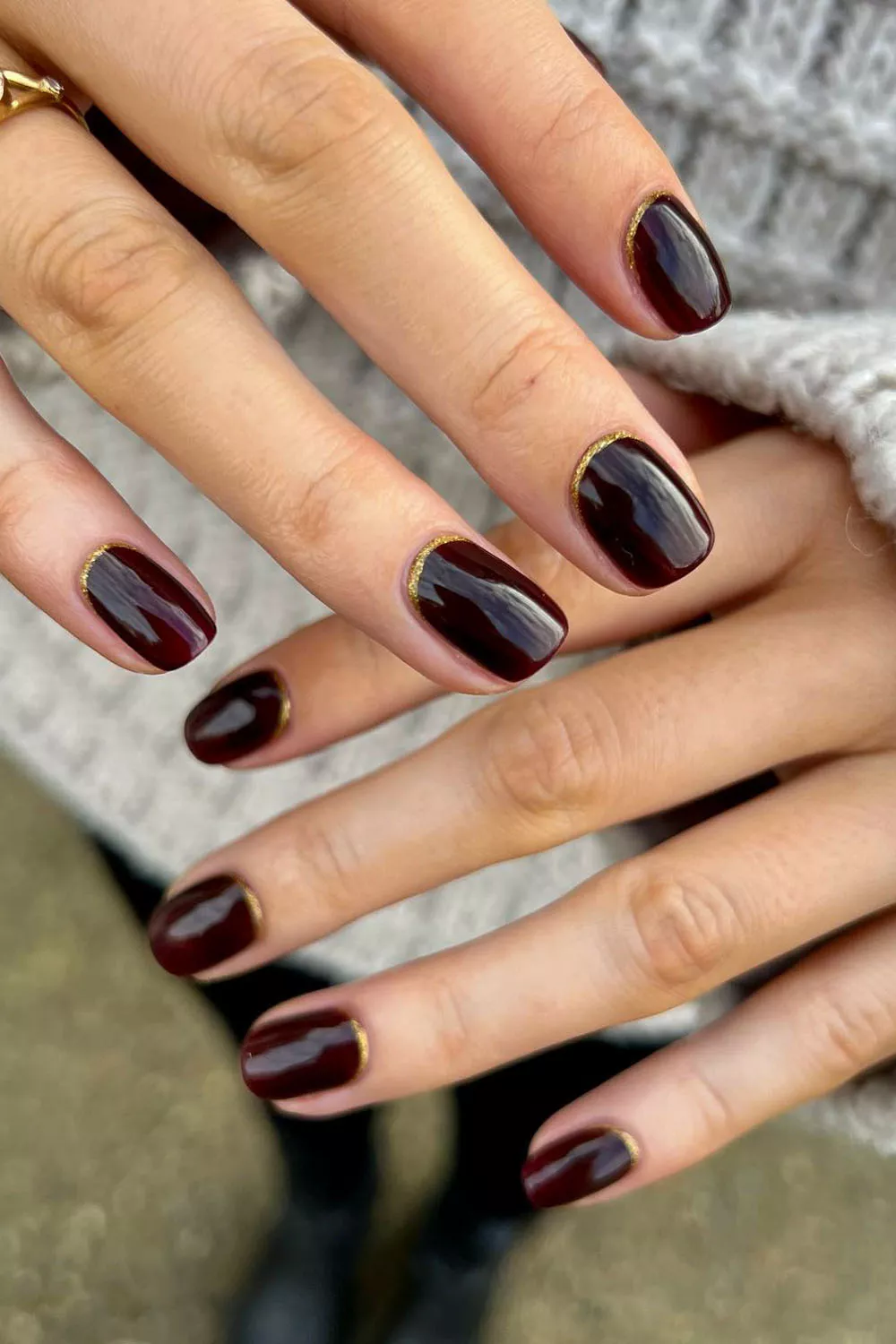 uñas de invierno en rojo vino con linea dorada en la base
